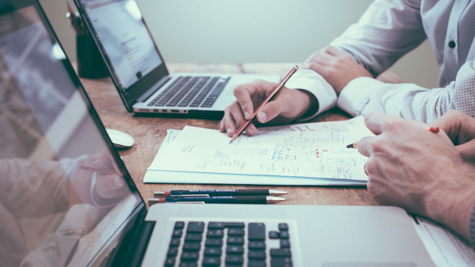 Laptop with financial charts and a notebook — representing a car rental business plan and financial projections
