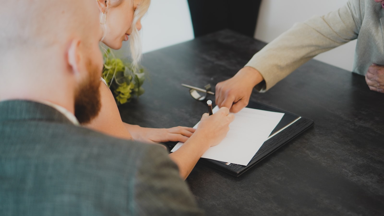 A rental agreement being signed at a desk — representing a signed car rental contract